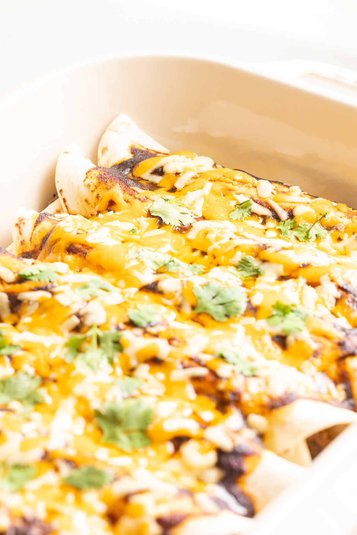 A white pan full of beef enchiladas.