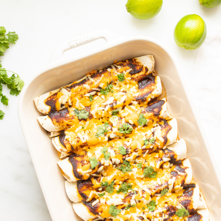 A white pan full of beef enchiladas.