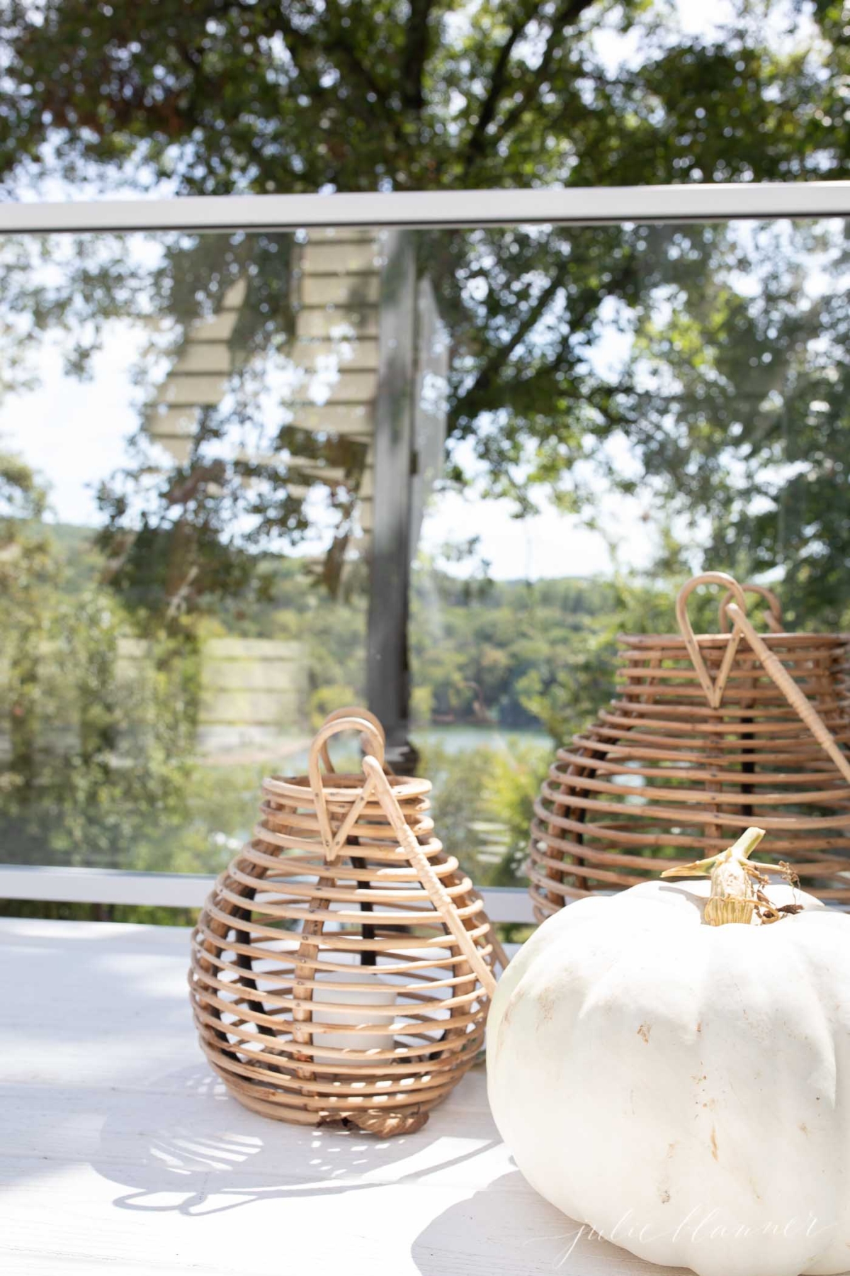 Rattan lanterns and a white pumpkin on a fall porch.