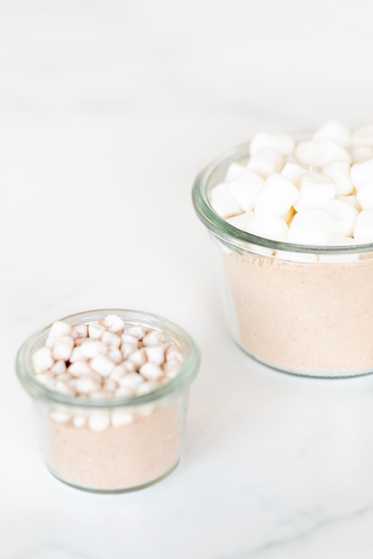 Homemade hot chocolate mix topped with marshmallows in a glass jar.