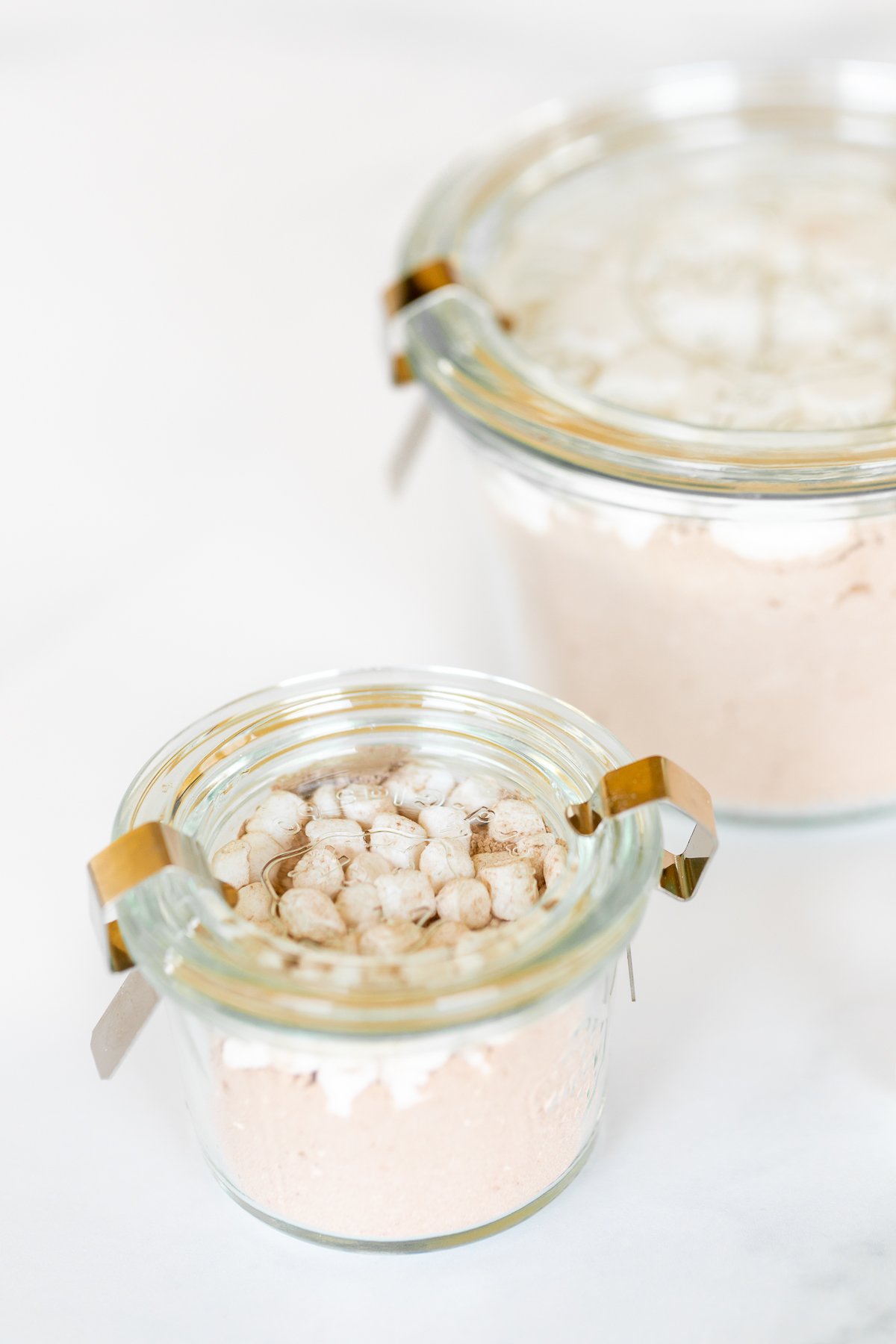 Homemade hot chocolate mix topped with marshmallows in a glass jar.