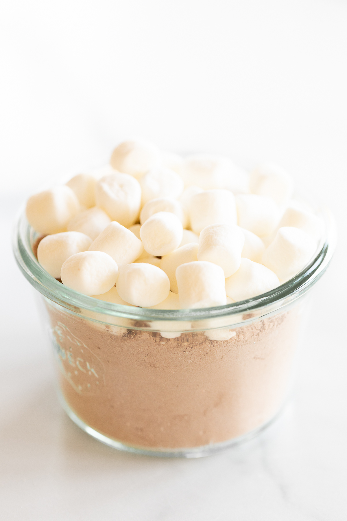 The best homemade hot chocolate mix, lovingly prepared in a glass bowl filled with delectable chocolate and fluffy marshmallows.
