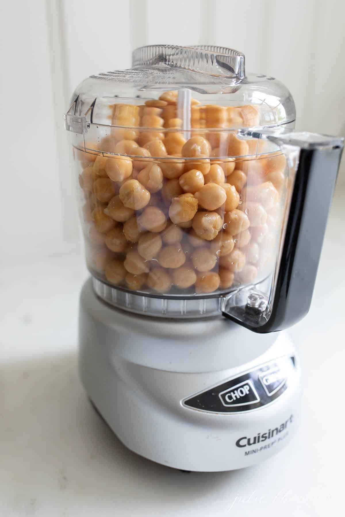 A food processor full of ingredients to make homemade hummus.