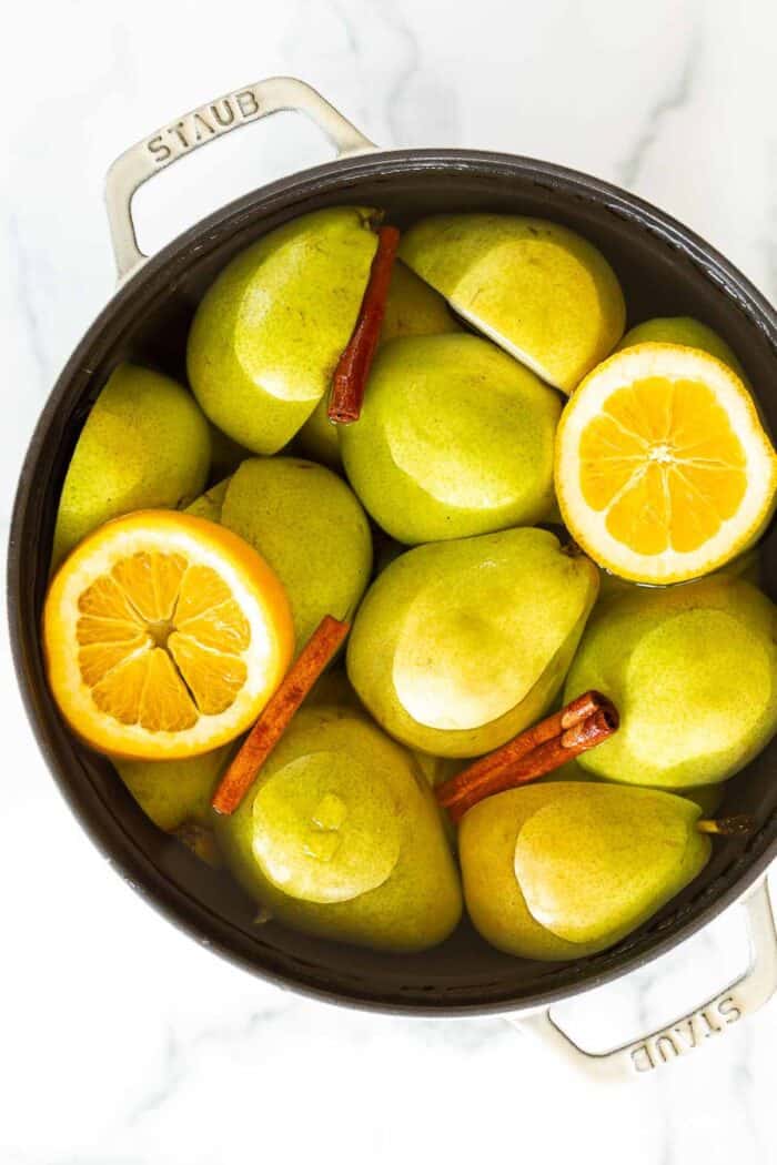 A cast iron pot filled with pear cider ingredients