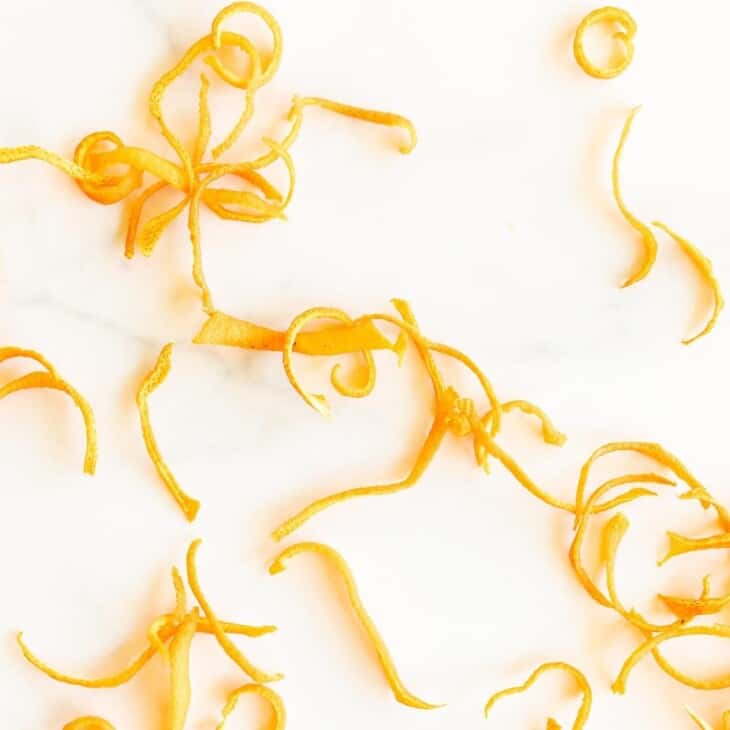 A marble surface with curls of dried orange zest.