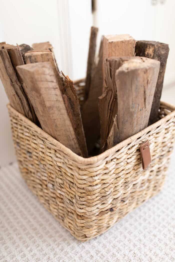 A textured basket filled with cut wood for a fireplace.
