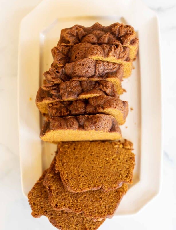 A white platter with a pumpkin bread recipe cut into slices