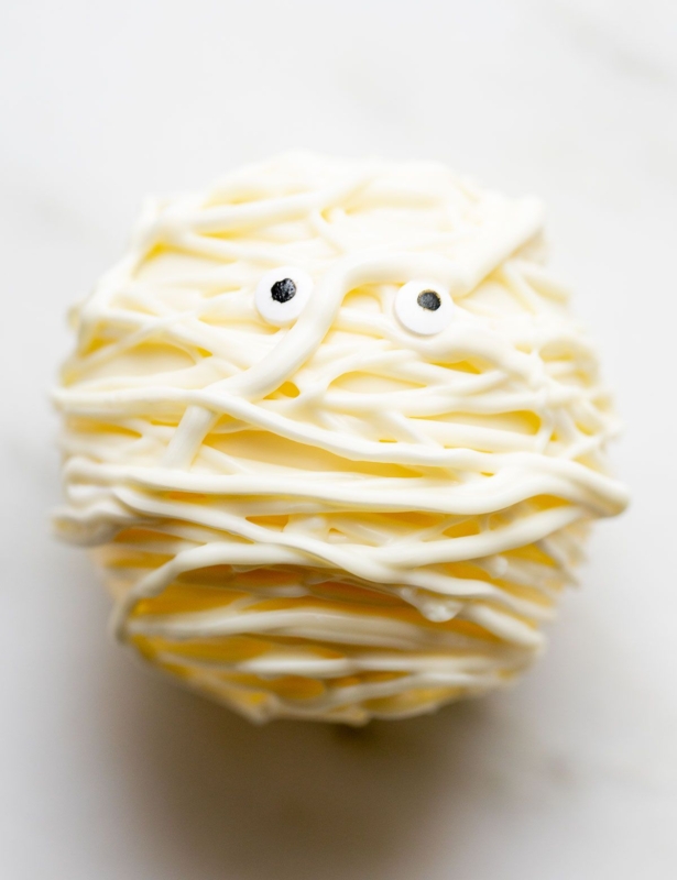 A white chocolate Halloween hot chocolate bomb, decorated as a mummy.