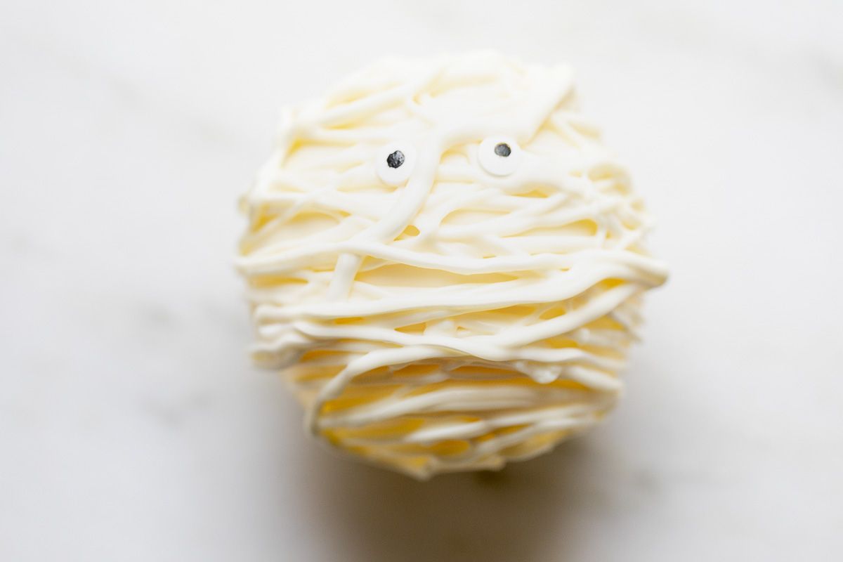 A white chocolate Halloween hot chocolate bomb, decorated as a mummy.