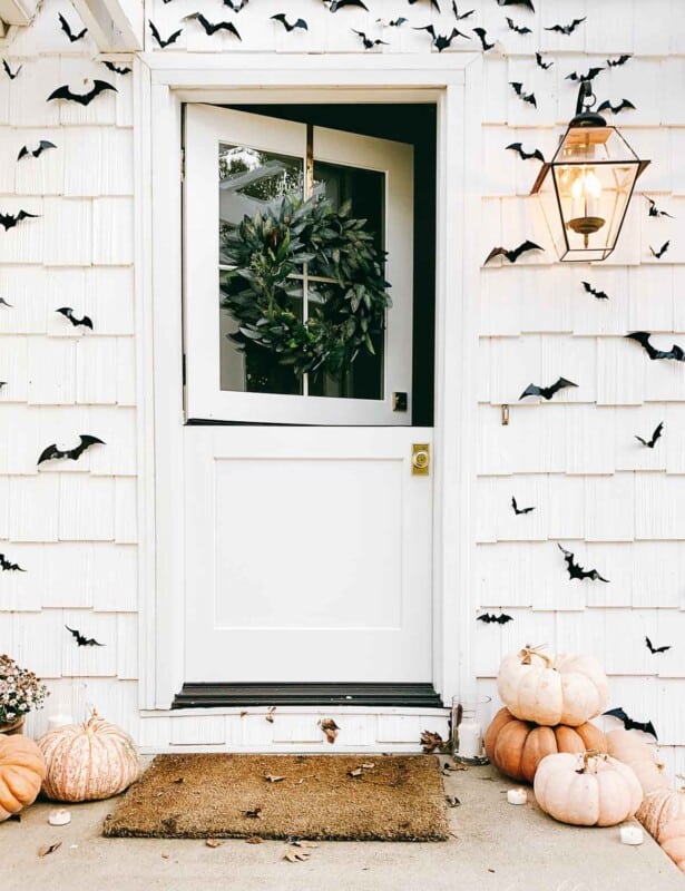 open dutch door surrounded by black bats and pumpkins