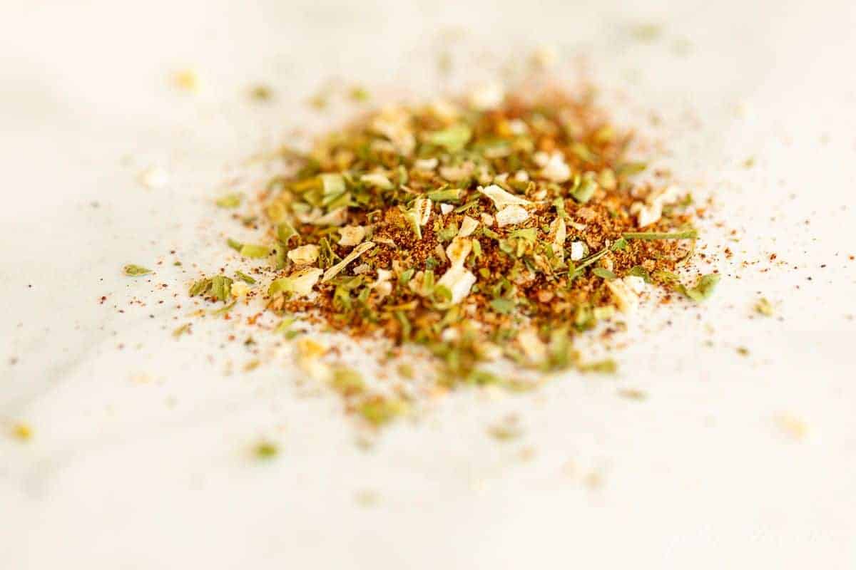 A pile of homemade fiesta ranch seasoning mix on a white surface.