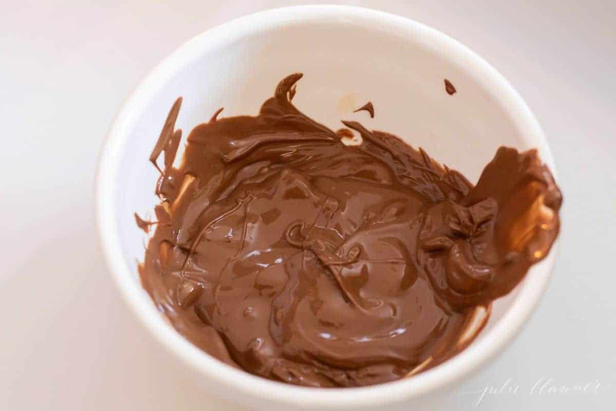 A white bowl full of melted chocolate.