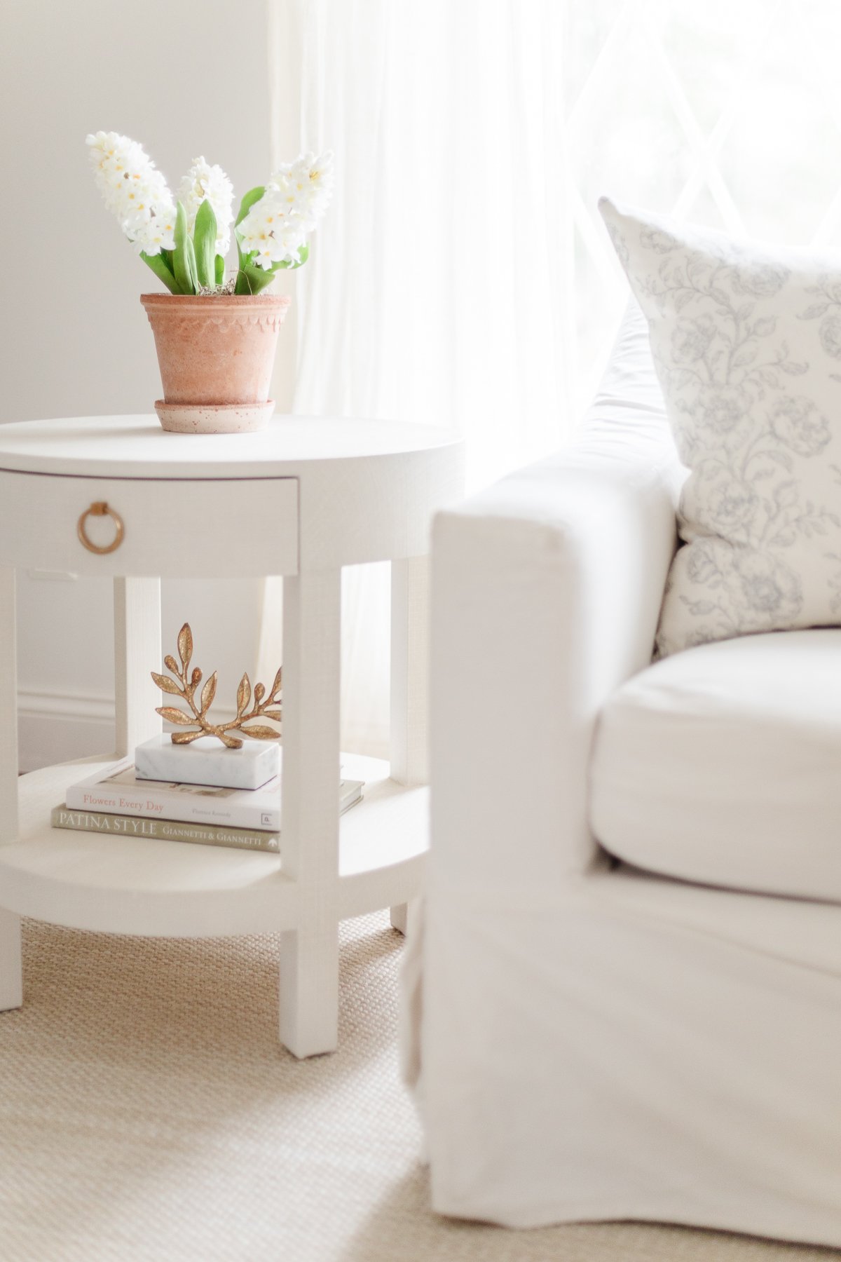 A living room with a minimalist aesthetic in shades of white.