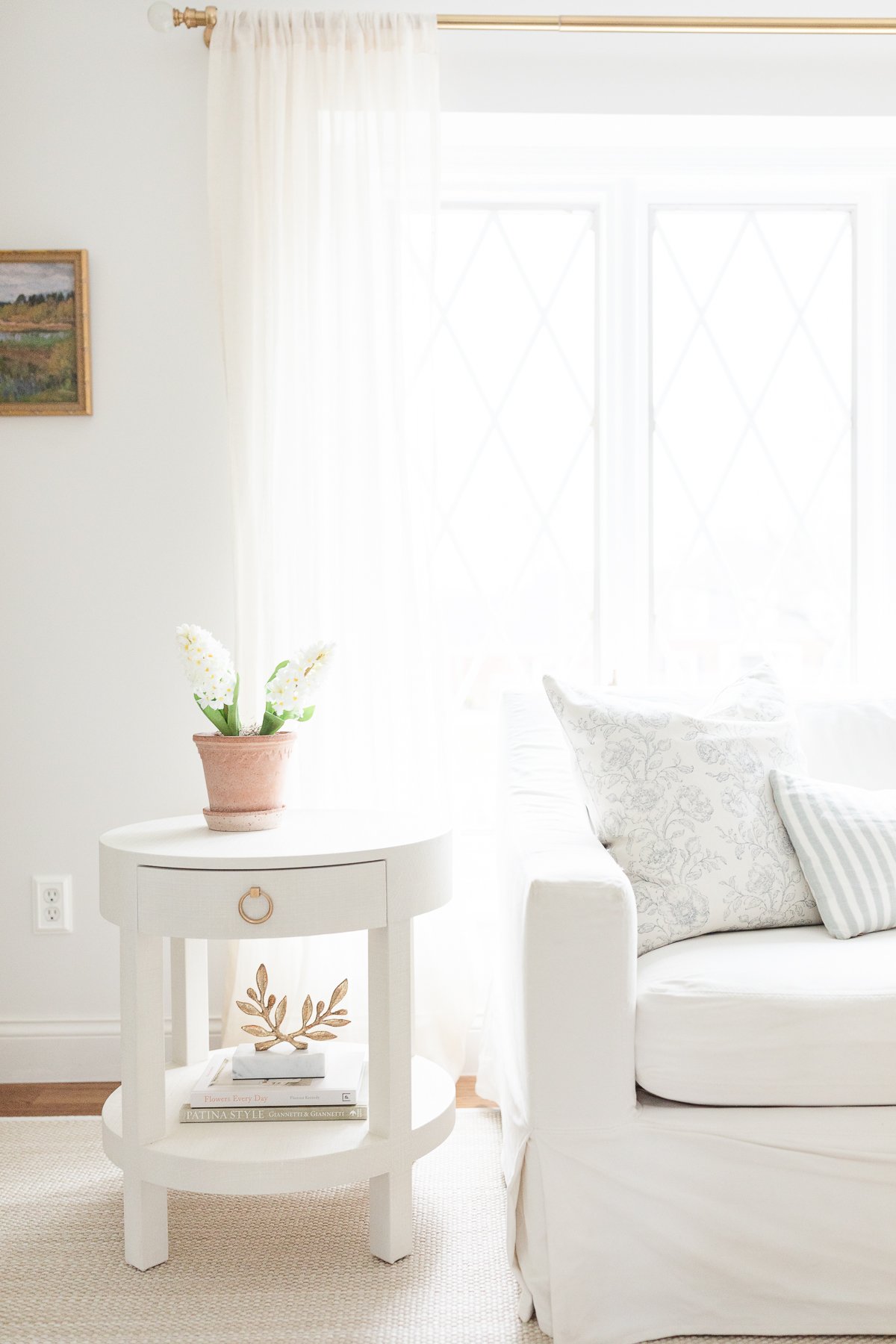 A living room with a minimalist aesthetic in shades of white.