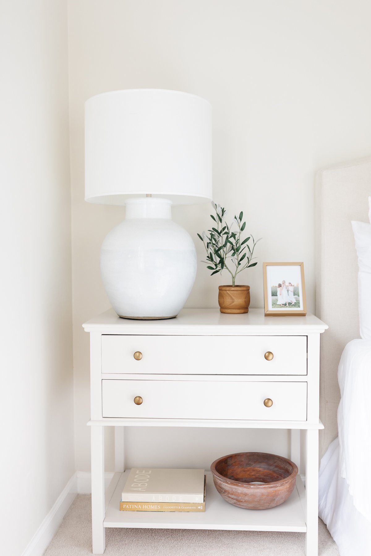 A bedroom with a minimalist aesthetic in shades of cream with touches of blue.