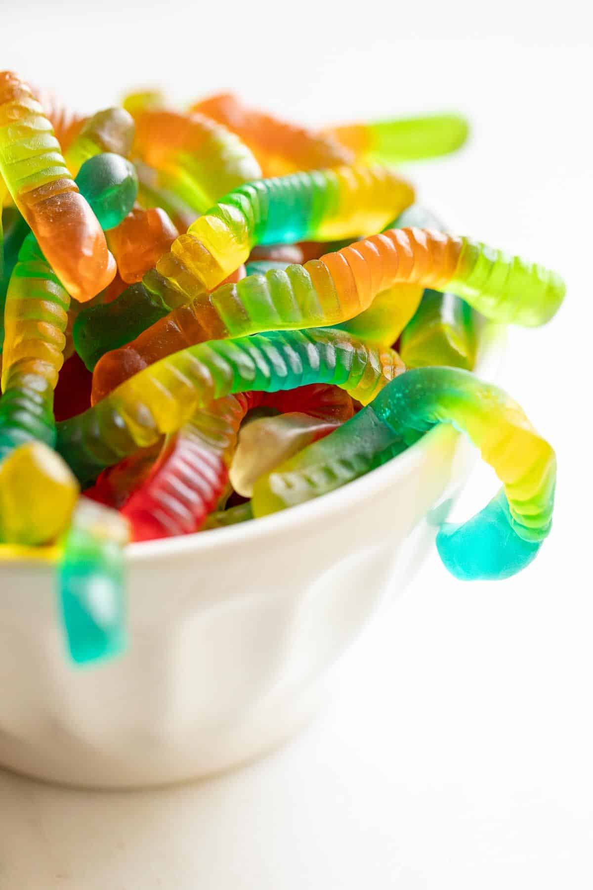 A white bowl full of gummy worms for a Halloween outdoor movie night.