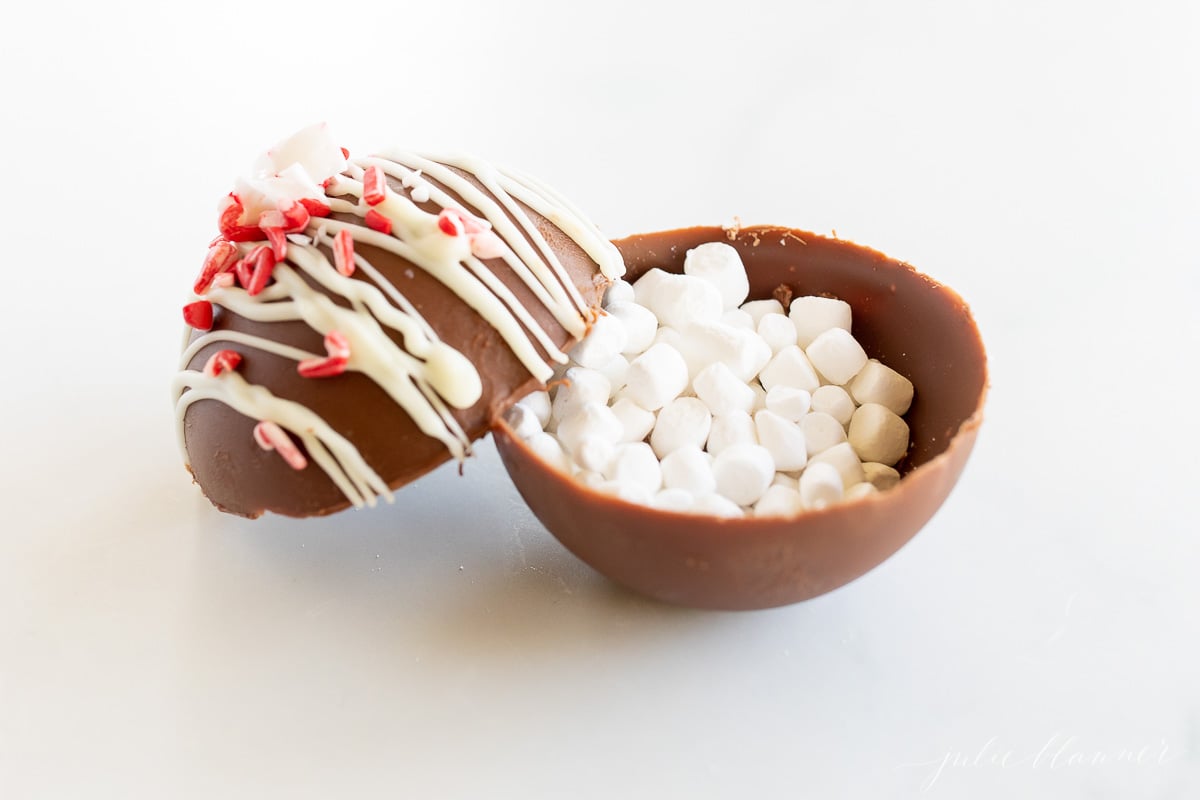 Peppermint hot chocolate bombs, a delightful treat consisting of a chocolate egg filled with marshmallows and sprinkles.