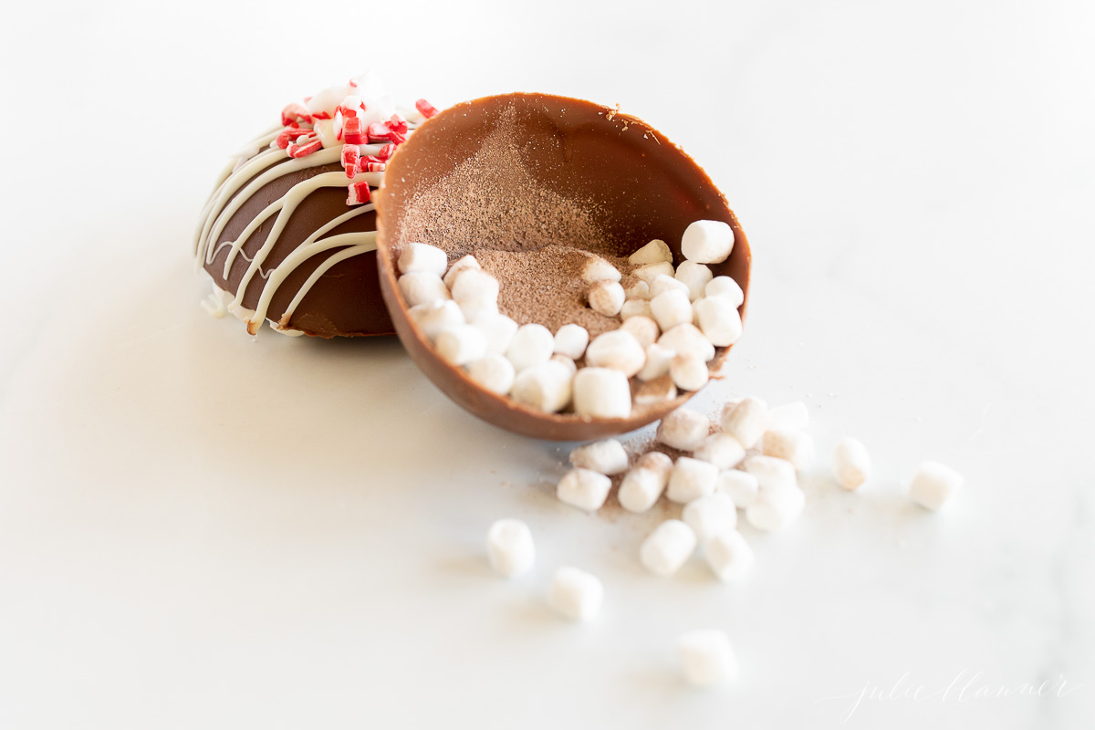 A peppermint hot chocolate bomb, filled with marshmallows and sprinkles.