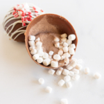 A peppermint hot chocolate bomb with marshmallows in it.