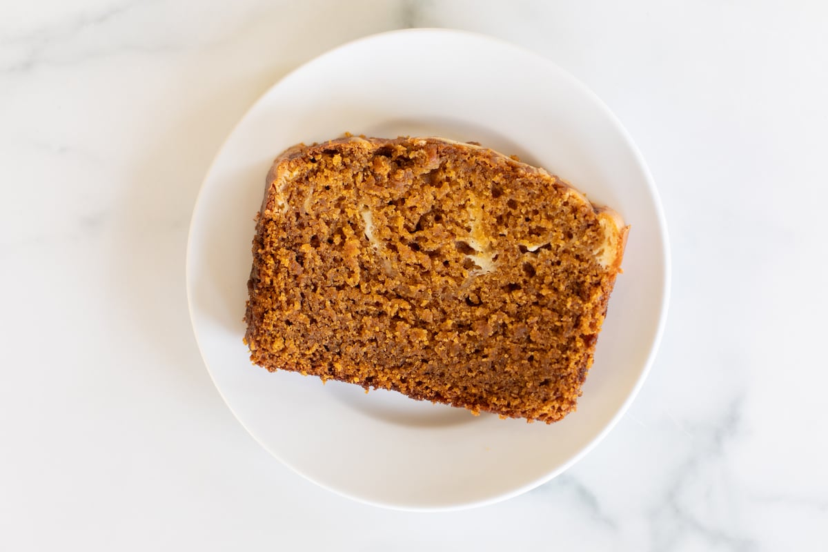 A slice of pumpkin cheesecake bread on a white plate.