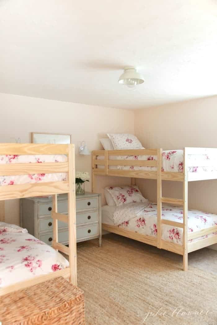 A sisal bedroom rug in a room with wooden bunk beds and floral bedding.