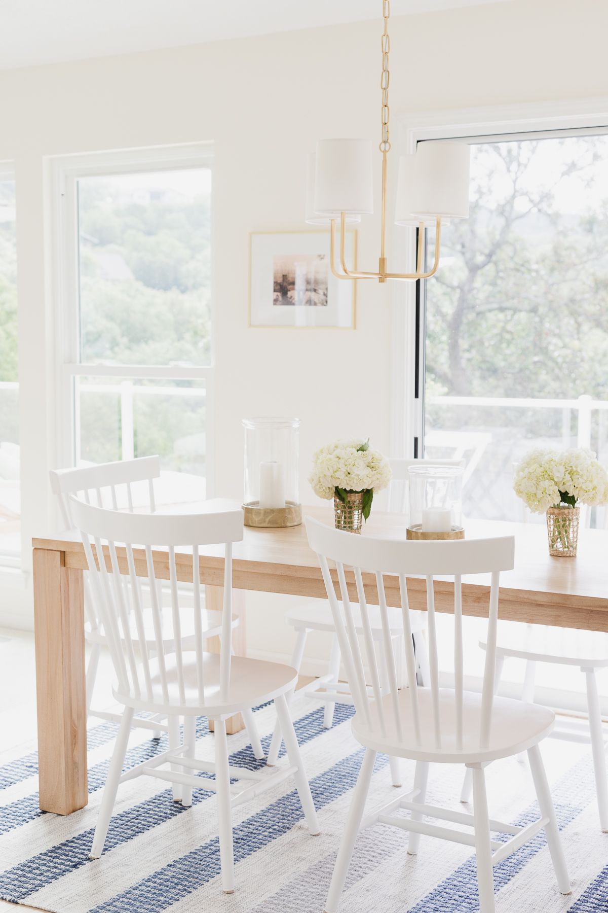 A striped rug under a soft wood dining table