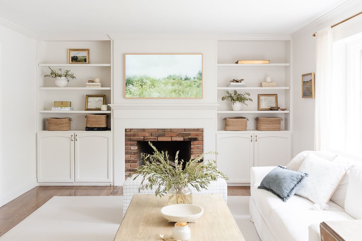 A white living room with a white rug and wood coffee table