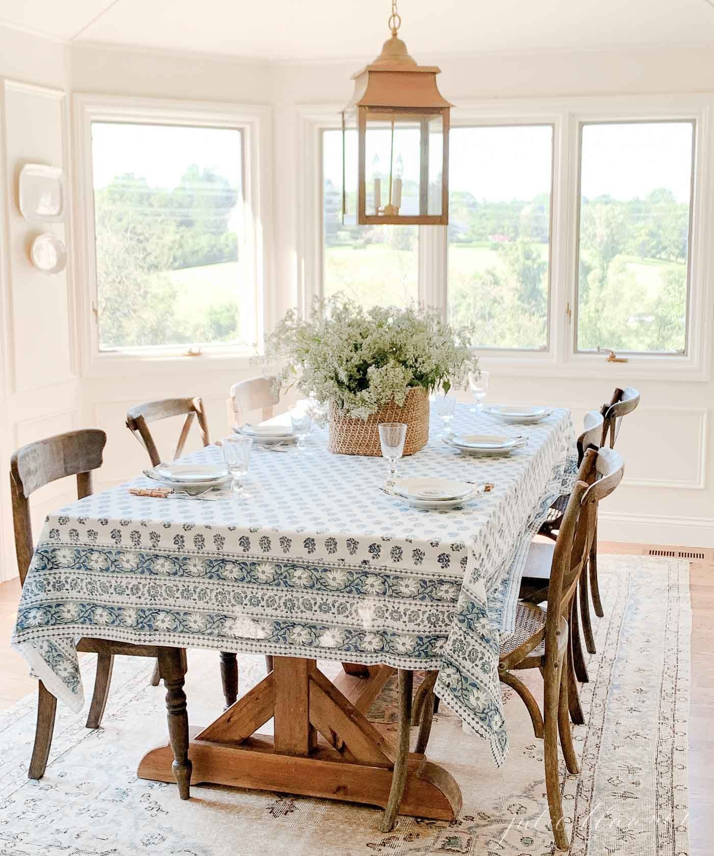 A dining room table with a vintage rug underneath