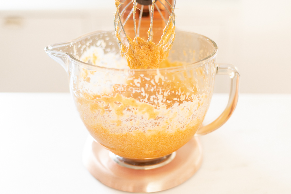 A copper stand mixer with a glass bowl, blending a sweet potato casserole recipe.