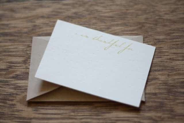 A simple white free printable card stating "I am thankful for" with an envelope behind it.