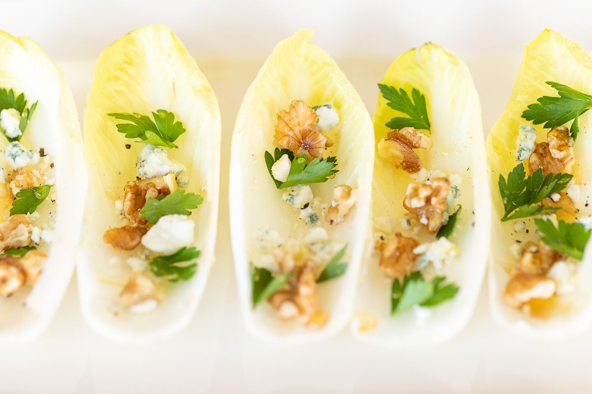 An endive salad laid out on a white platter.