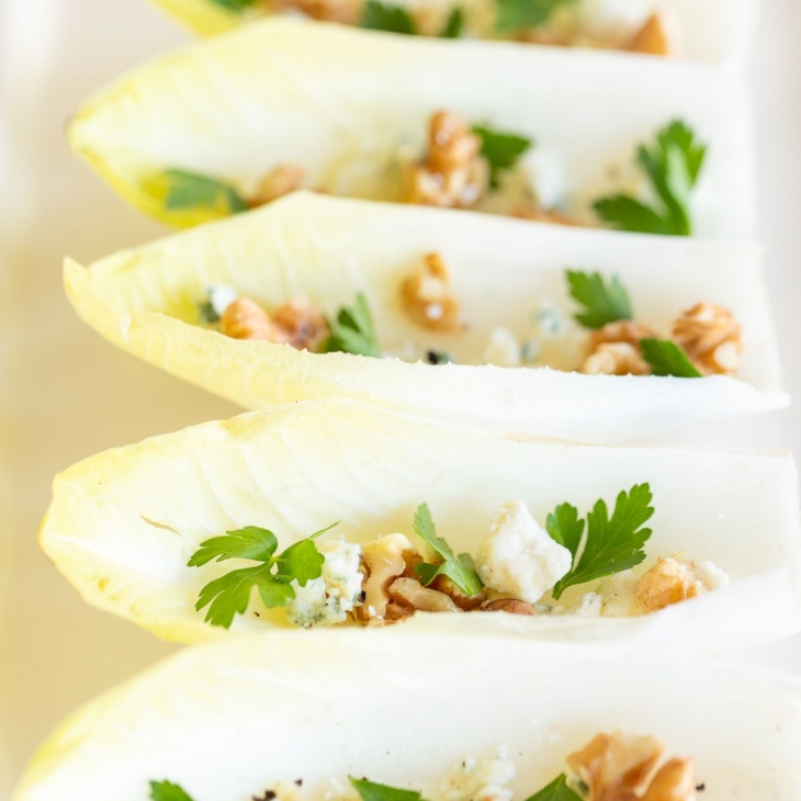 An endive salad laid out on a white platter.