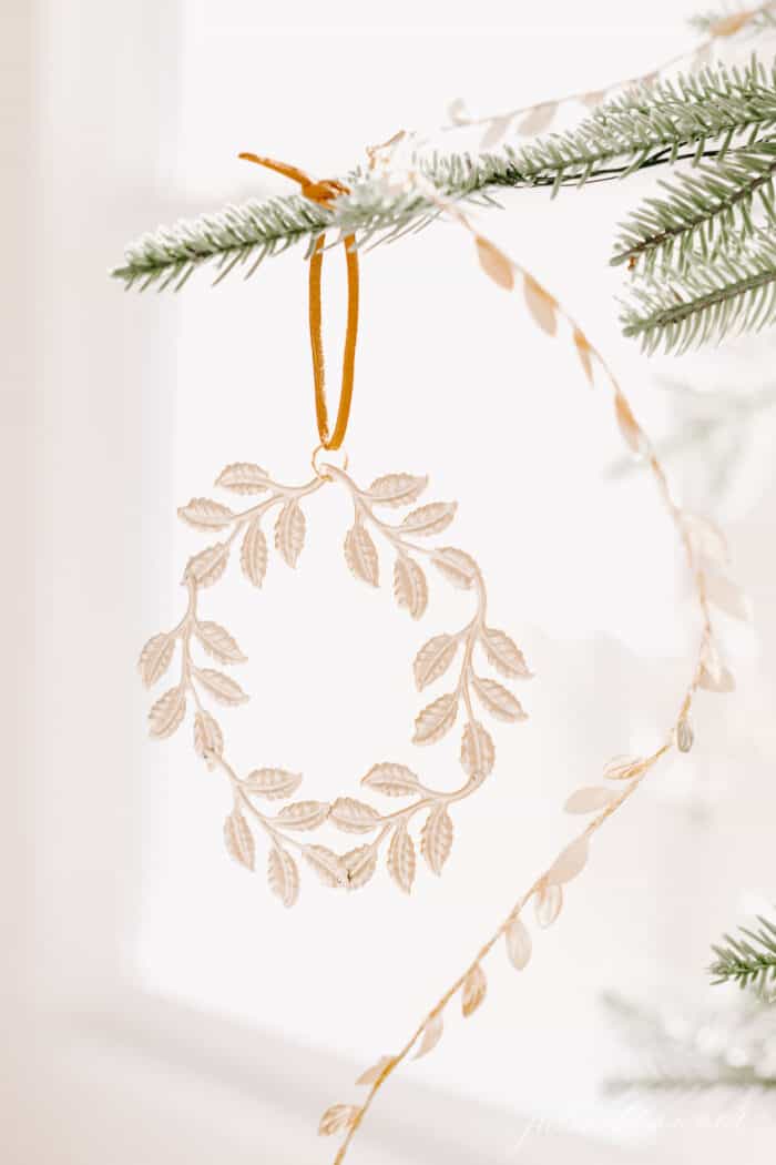 A close up of a gold wreath ornament on a Scandinavian tree.