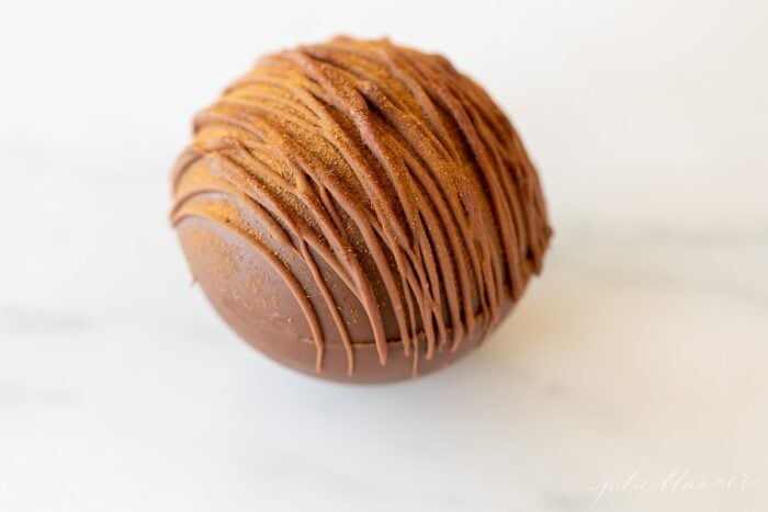 a single spicy hot chocolate bomb on a marble surface
