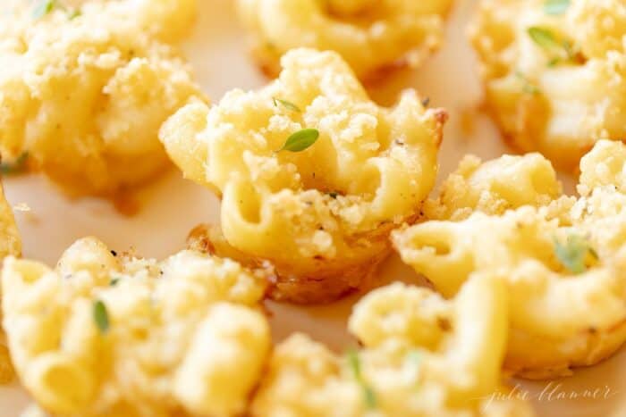 Mac and cheese cups on a white platter.