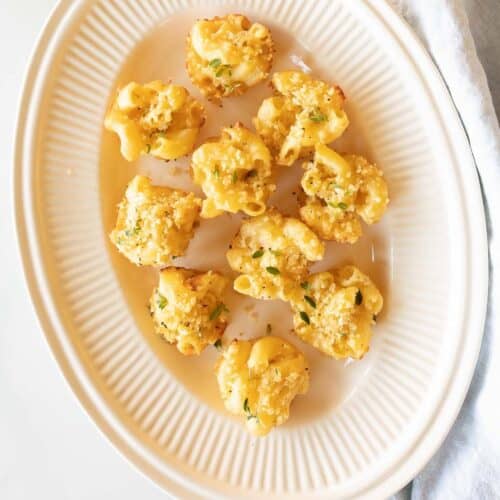 Mac and cheese cups on a white platter.