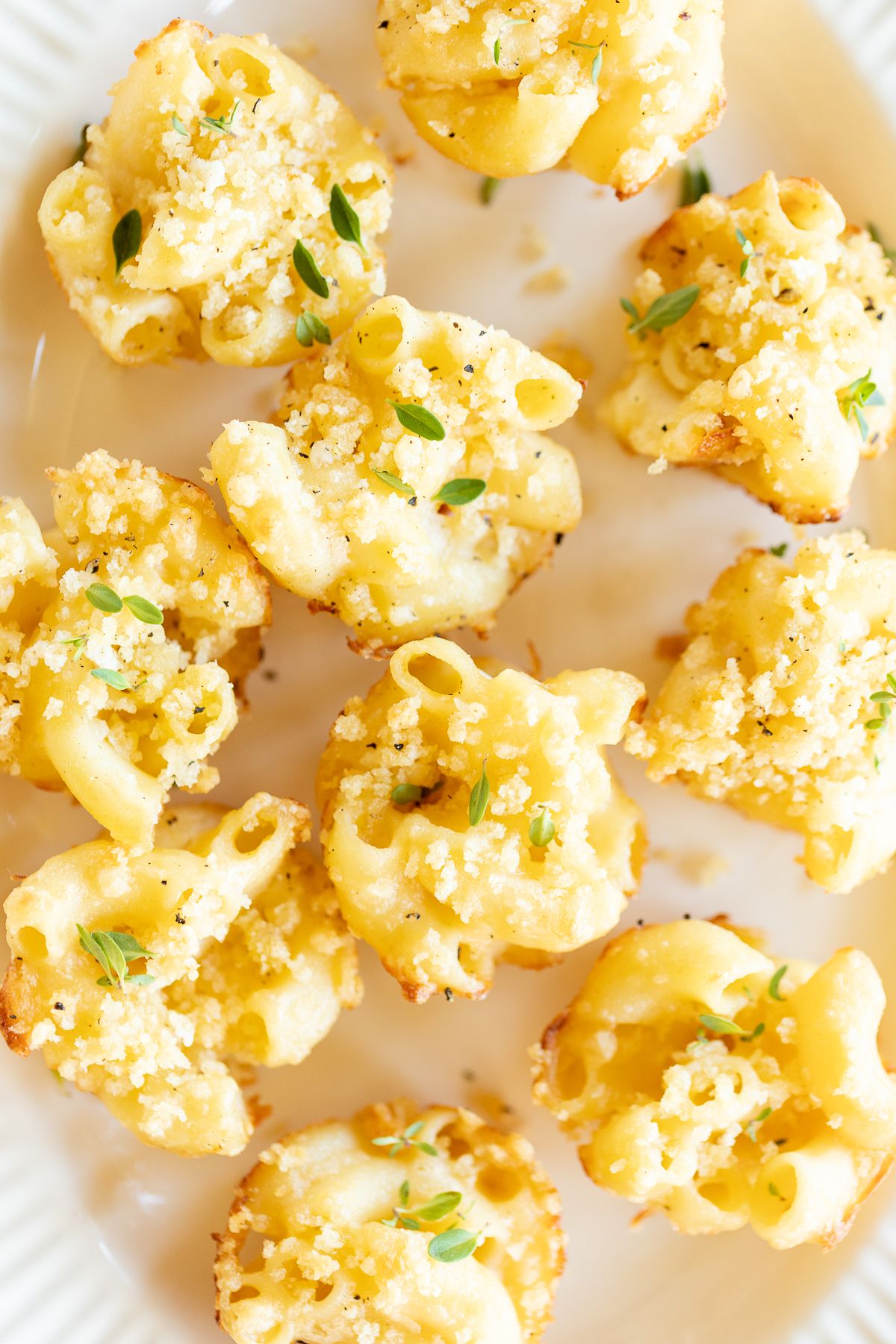 A platter full of mini mac and cheese cups for an appetizer.