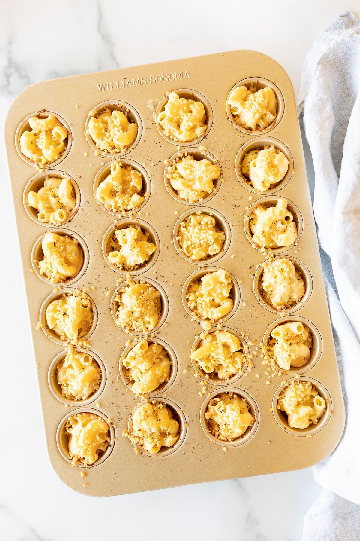 A mini muffin tin filled with mac and cheese cups.