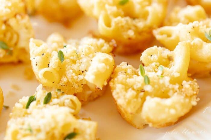Mac and cheese cups on a white platter.