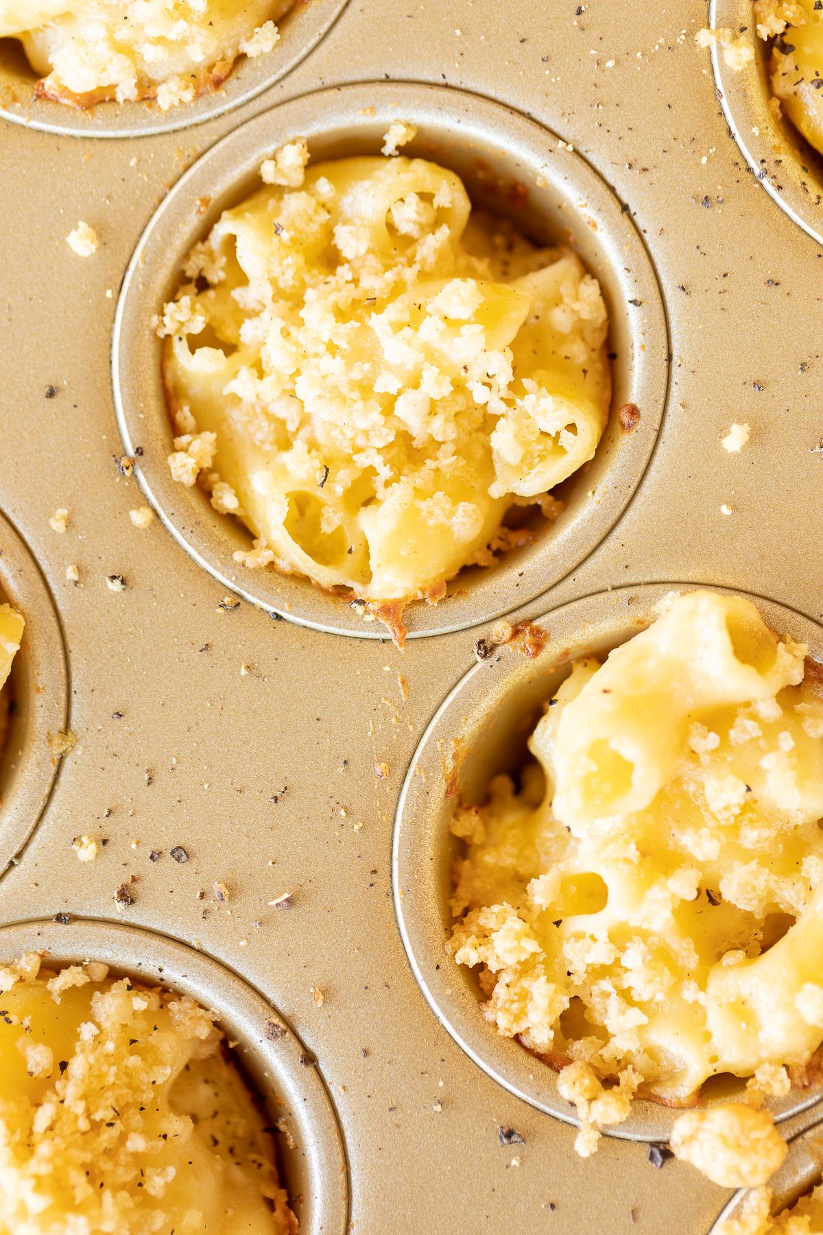 A mini muffin tin filled with mac and cheese cups.