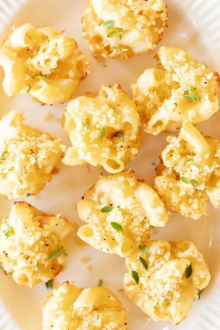 Mac and cheese cups on a white platter.