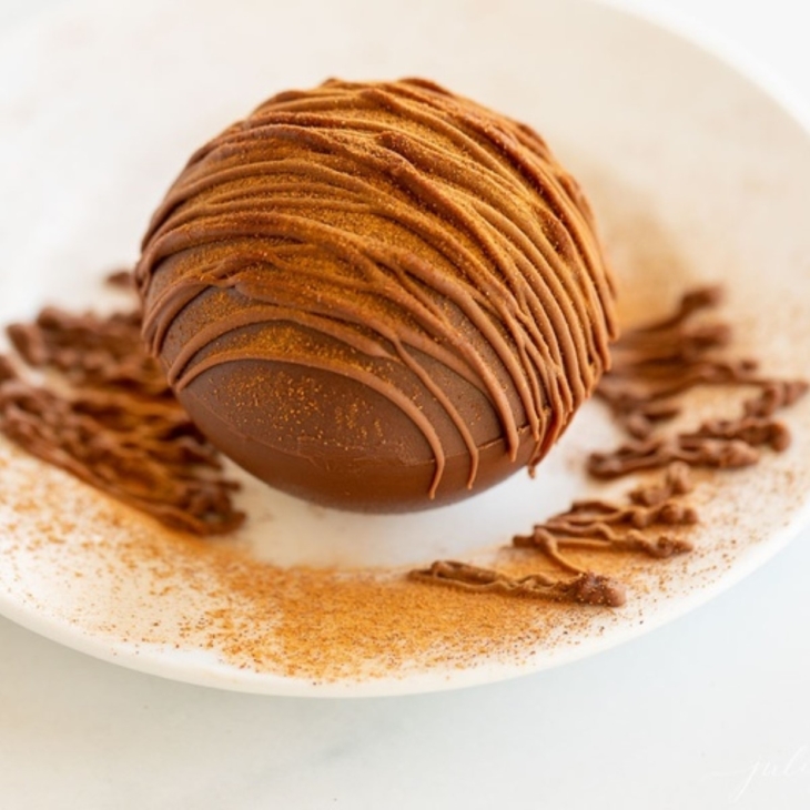 Mexican hot chocolate bomb on a white plate.