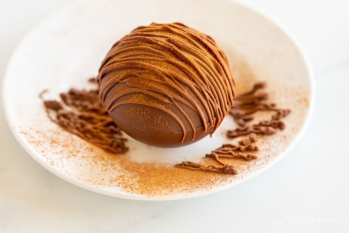 Mexican hot chocolate bomb on a white plate.