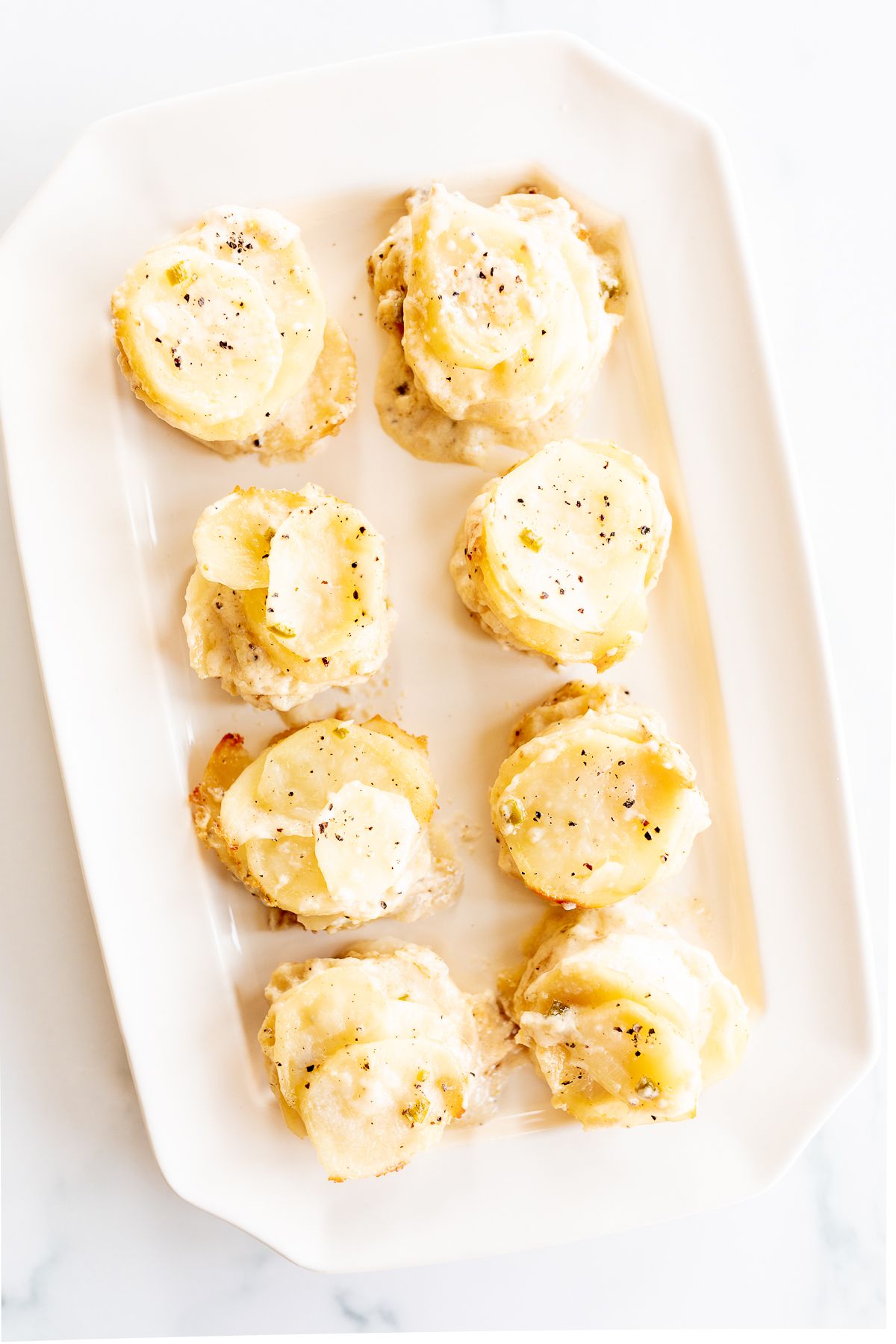 A white platter featuring potato gratin stacks.