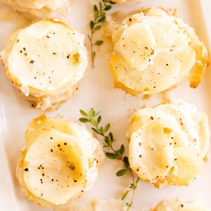 stacks of potatoes on a platter with thyme in center