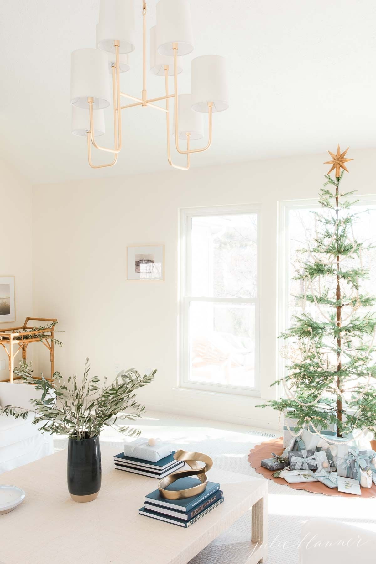 A white living room dressed for a Scandinavian Christmas with a simple Scandinavian tree.