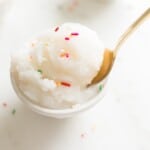 snow ice cream topped with sprinkles and served with gold spoon