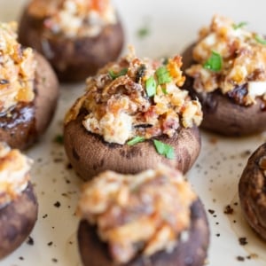 An oval white platter filled with bacon stuffed mushrooms