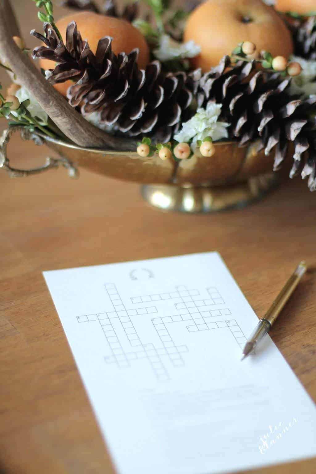 A printable Thanksgiving crossword puzzle on a wooden table with a gold centerpiece in the background.