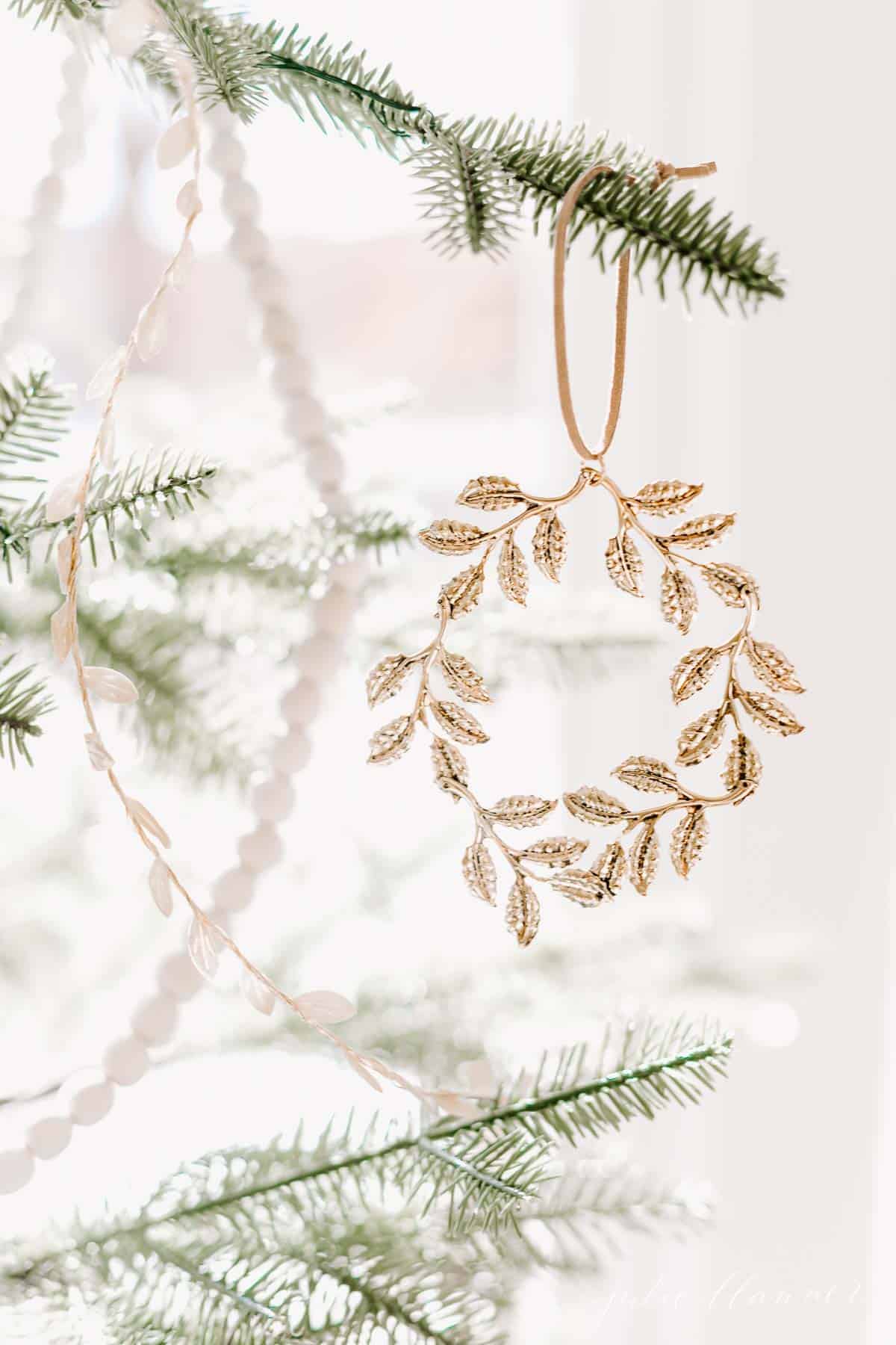 A close up of a gold wreath ornament on a Scandinavian Christmas tree.